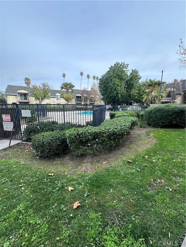 view of yard featuring a community pool and fence