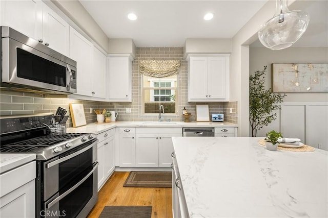 109 Baculo St, Rancho Mission Viejo, CA 92694 - kitchen featuring white cabinets, light wood-type flooring, stainless steel appliances, and a sink