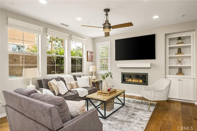 109 Baculo St, Rancho Mission Viejo, CA 92694 - living area with recessed lighting, hardwood / wood-style floors, visible vents, a ceiling fan, and a glass covered fireplace