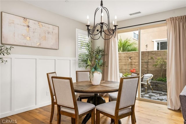 109 Baculo St, Rancho Mission Viejo, CA 92694 - dining space featuring a decorative wall, a chandelier, light wood-type flooring, a wainscoted wall, and visible vents