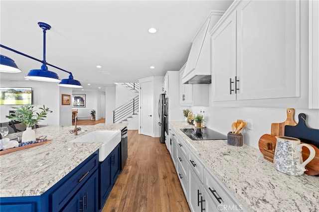 kitchen featuring blue cabinetry, appliances with stainless steel finishes, a sink, recessed lighting, and white cabinetry