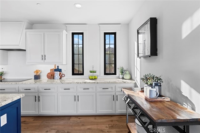 41950 Hacienda Dr, Murrieta, CA 92562 - kitchen with black electric stovetop, white cabinets, dark wood-style flooring, and light stone countertops