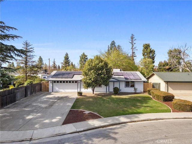513 River Oaks Dr, Bakersfield, CA 93309 - ranch-style home featuring a front lawn, concrete driveway, fence, an attached garage, and roof mounted solar panels