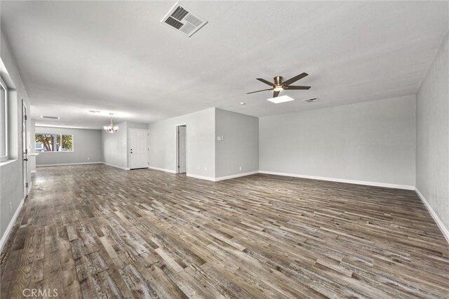 513 River Oaks Dr, Bakersfield, CA 93309 - unfurnished living room featuring ceiling fan with notable chandelier, baseboards, wood finished floors, and visible vents
