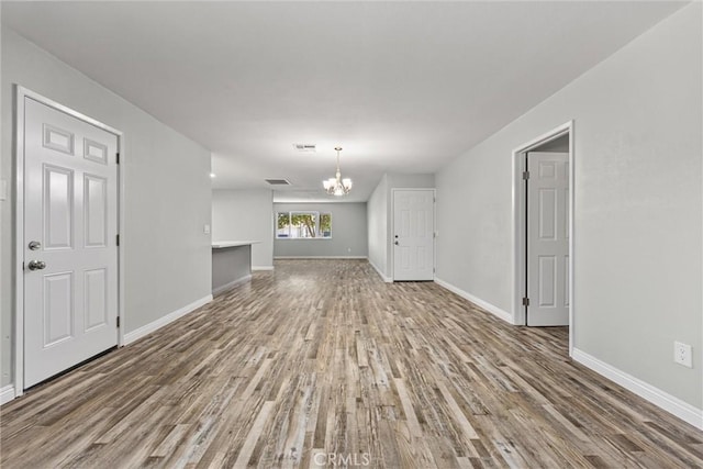 513 River Oaks Dr, Bakersfield, CA 93309 - unfurnished living room with wood finished floors, visible vents, baseboards, and a notable chandelier
