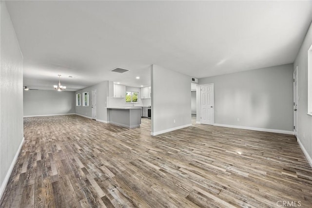 513 River Oaks Dr, Bakersfield, CA 93309 - unfurnished living room featuring wood finished floors, baseboards, a notable chandelier, visible vents, and recessed lighting