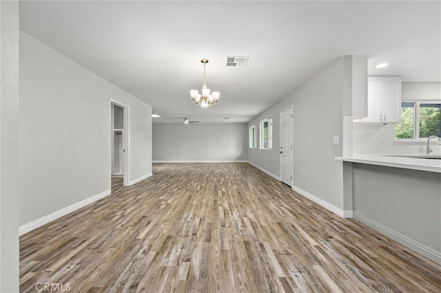 513 River Oaks Dr, Bakersfield, CA 93309 - unfurnished living room featuring visible vents, baseboards, wood finished floors, and a chandelier