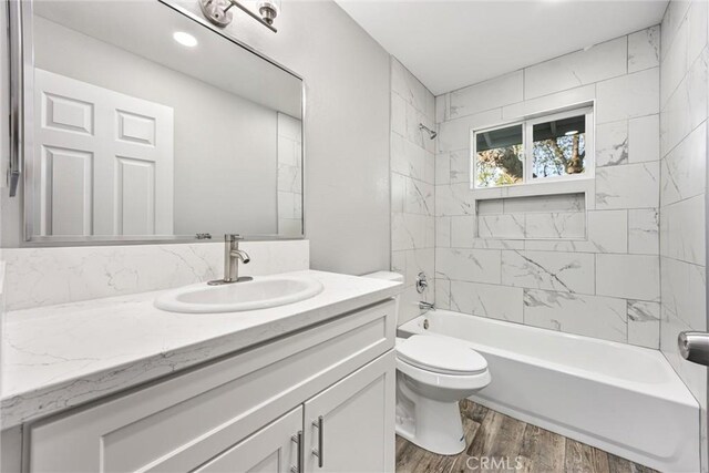 513 River Oaks Dr, Bakersfield, CA 93309 - bathroom with washtub / shower combination, wood finished floors, toilet, and vanity