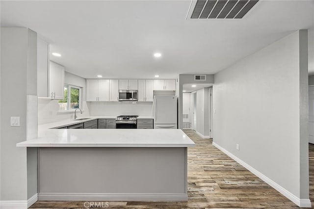 513 River Oaks Dr, Bakersfield, CA 93309 - kitchen featuring light wood finished floors, stainless steel appliances, a sink, visible vents, and light countertops