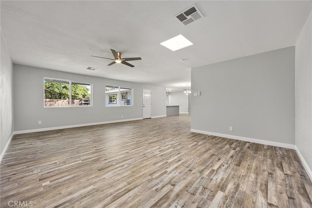513 River Oaks Dr, Bakersfield, CA 93309 - unfurnished living room featuring ceiling fan with notable chandelier, baseboards, wood finished floors, and visible vents