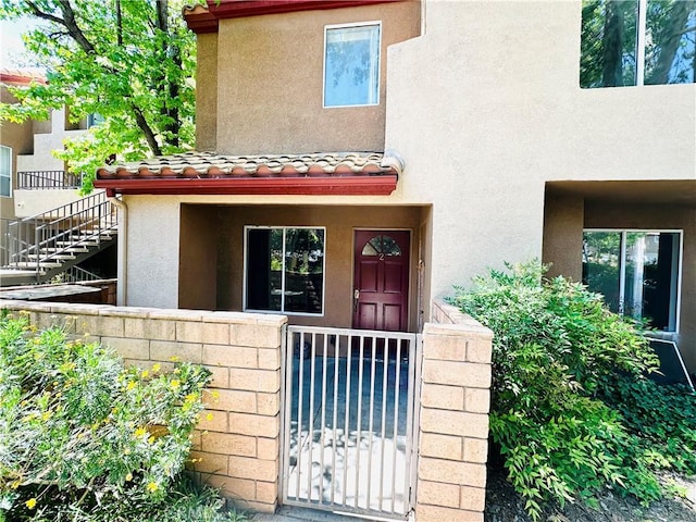 22703 Copper Hill Dr Unit 2, Saugus, CA 91350 - view of exterior entry featuring fence, a tiled roof, and stucco siding