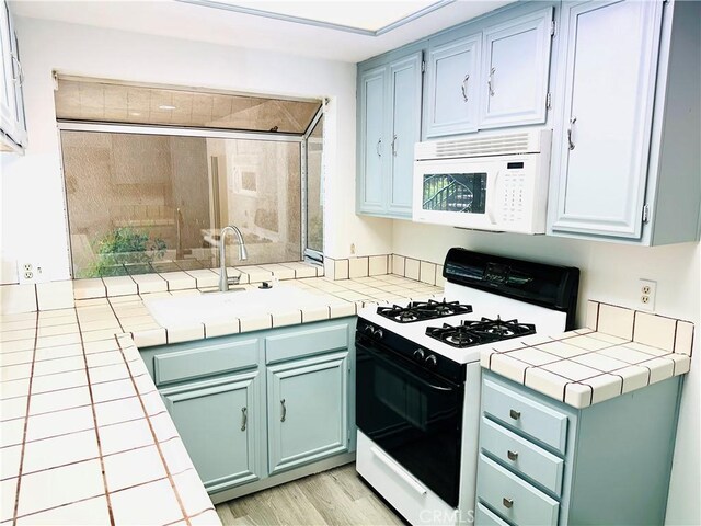 22703 Copper Hill Dr Unit 2, Saugus, CA 91350 - kitchen featuring light wood finished floors, tile counters, and white appliances