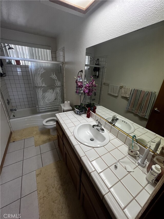 16389 Viho Ct, Apple Valley, CA 92307 - bathroom with vanity, bath / shower combo with glass door, toilet, and tile patterned flooring