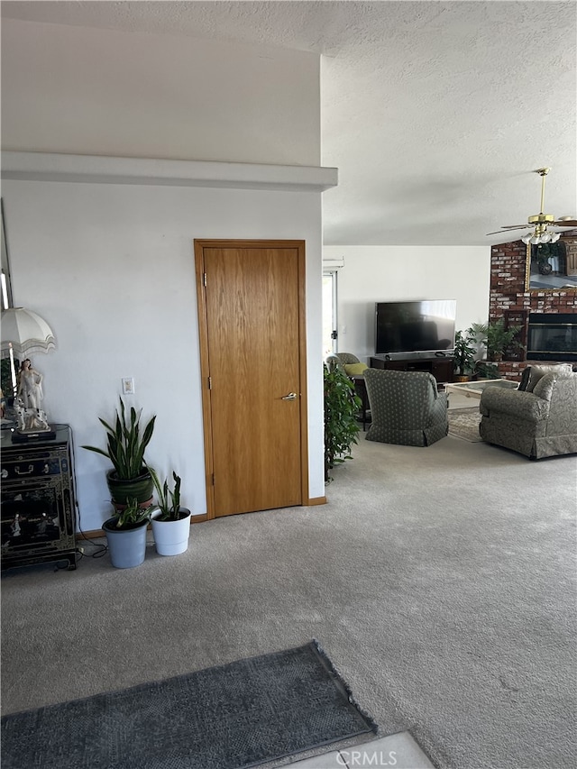 16389 Viho Ct, Apple Valley, CA 92307 - living room with a ceiling fan, carpet, a textured ceiling, and a fireplace