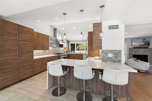 3120 Bern Dr, Laguna Beach, CA 92651 - kitchen with wall chimney range hood, a breakfast bar, modern cabinets, decorative backsplash, and lofted ceiling