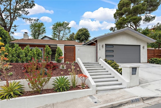 3120 Bern Dr, Laguna Beach, CA 92651 - view of front of house with concrete driveway, an attached garage, stairs, and a chimney