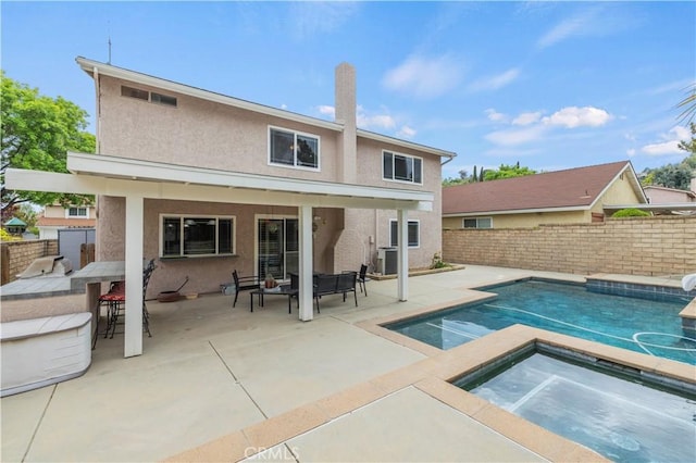 21643 Spice Ct, Saugus, CA 91350 - rear view of property featuring an in-ground hot tub, stucco siding, a fenced backyard, and a patio
