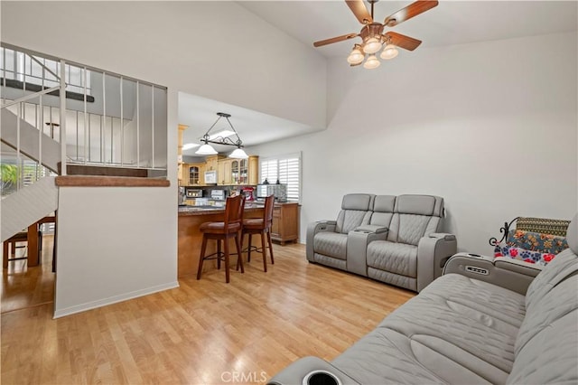 21643 Spice Ct, Saugus, CA 91350 - living area with a ceiling fan, light wood-style flooring, stairway, and a towering ceiling