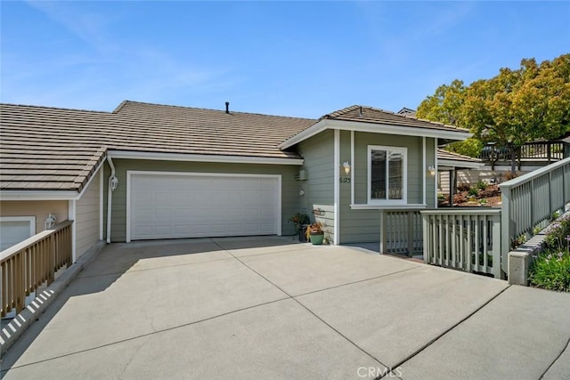 ranch-style house with a tile roof, driveway, and an attached garage