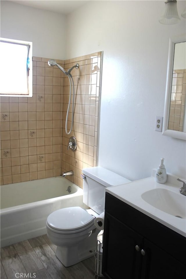 bathroom featuring toilet, vanity, wood finished floors, and tub / shower combination