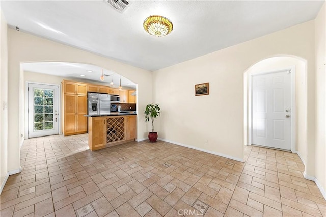 228 S Norman Ave, Fullerton, CA 92831 - interior space featuring stainless steel appliances, dark countertops, visible vents, arched walkways, and baseboards