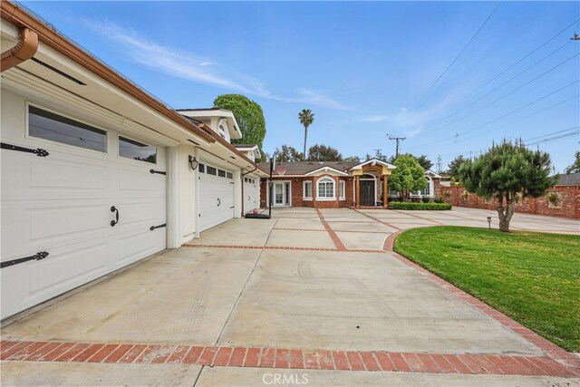 view of front of house with a garage, driveway, and a front yard