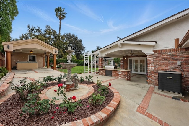 view of yard featuring a ceiling fan, exterior kitchen, cooling unit, french doors, and a patio