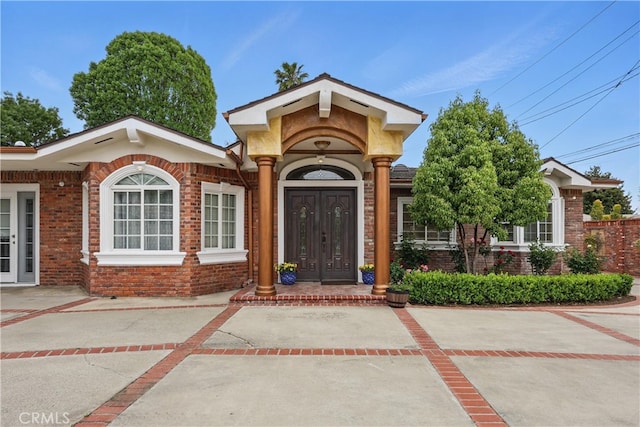 view of exterior entry featuring brick siding