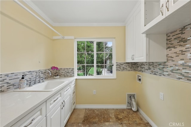 laundry room with hookup for a washing machine, a sink, cabinet space, baseboards, and ornamental molding