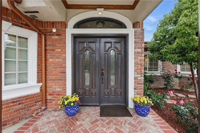 doorway to property featuring brick siding