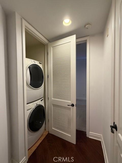 855 Wilcox Ave Unit 103, Los Angeles, CA 90038 - washroom with stacked washing machine and dryer, dark wood-style flooring, baseboards, and recessed lighting