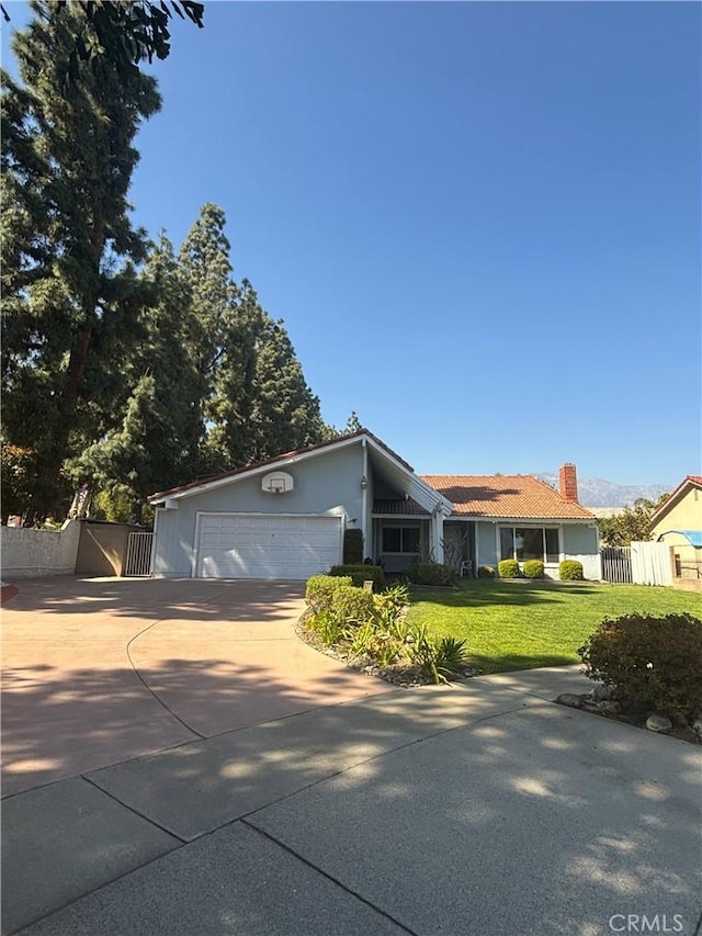 1193 W Molly Ct, Upland, CA 91786 - view of front of property with a front lawn, a garage, driveway, a chimney, and fence