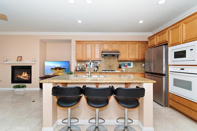 15785 Approach Ave, Chino, CA 91708 - kitchen featuring stainless steel appliances, under cabinet range hood, light stone countertops, tasteful backsplash, and a kitchen island with sink