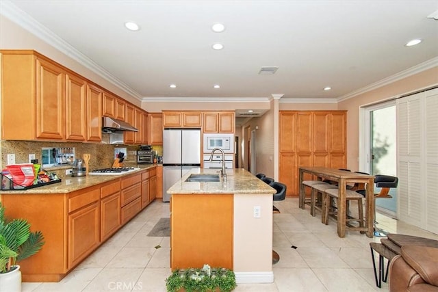 15785 Approach Ave, Chino, CA 91708 - kitchen with under cabinet range hood, light tile patterned floors, a sink, freestanding refrigerator, and white microwave