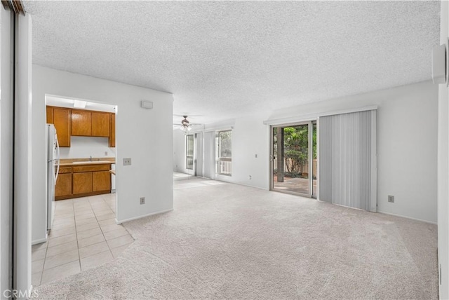 254 Sequoia Ct Unit 12, Thousand Oaks, CA 91360 - unfurnished living room featuring a textured ceiling, a sink, light tile patterned floors, ceiling fan, and light carpet