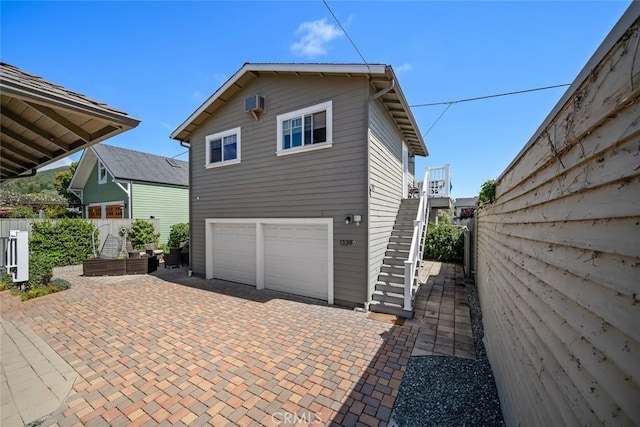 1339 Higuera St, San Luis Obispo, CA 93401 - exterior space with a wall mounted air conditioner, stairs, fence, an attached garage, and decorative driveway