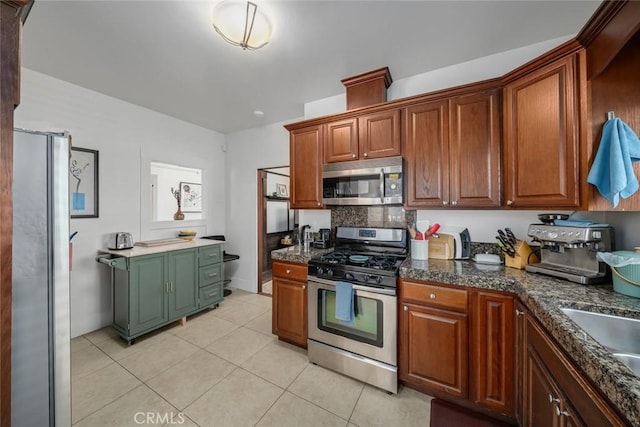 1339 Higuera St, San Luis Obispo, CA 93401 - kitchen featuring dark countertops, a sink, light tile patterned floors, brown cabinetry, and appliances with stainless steel finishes
