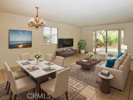 living room featuring a textured ceiling, a notable chandelier, and light tile patterned floors