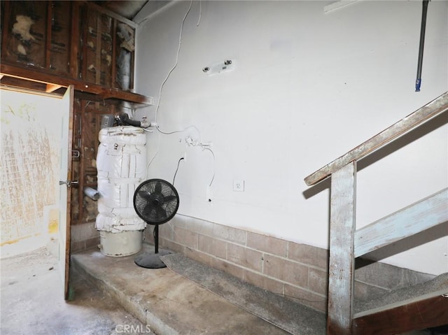 interior space with concrete block wall and unfinished concrete flooring