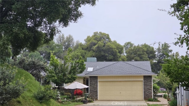 view of front of property featuring a garage, stone siding, concrete driveway, and a shingled roof