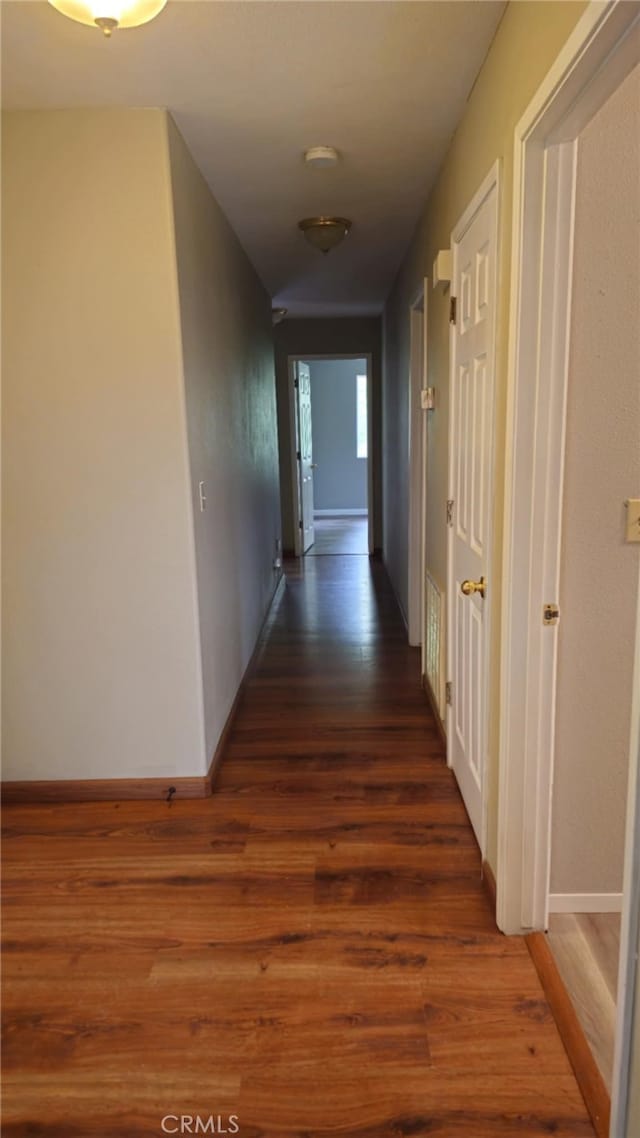 corridor with wood finished floors and baseboards