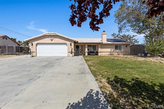 ranch-style house with a chimney, stucco siding, roof mounted solar panels, a front lawn, and an attached garage