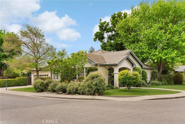 226 Stony Creek Dr, Orland, CA 95963 - view of front of house featuring a front lawn, stucco siding, a tiled roof, concrete driveway, and an attached garage