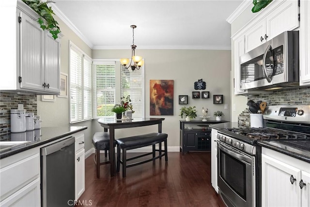 226 Stony Creek Dr, Orland, CA 95963 - kitchen featuring dark countertops, appliances with stainless steel finishes, decorative backsplash, and a notable chandelier
