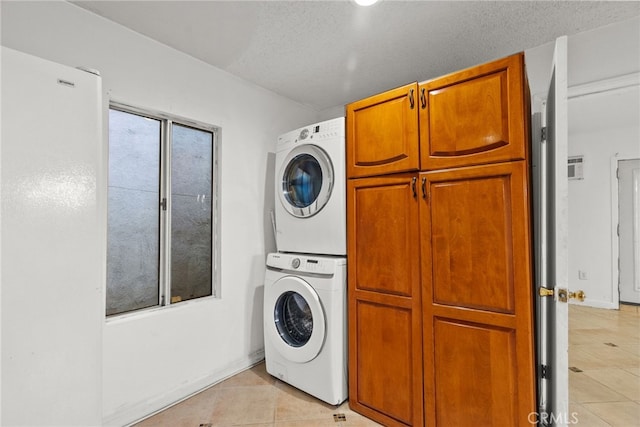 15430 Parthenia St, North Hills, CA 91343 - washroom featuring cabinet space, stacked washer and dryer, a textured ceiling, and light tile patterned floors