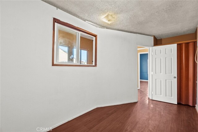 15430 Parthenia St, North Hills, CA 91343 - unfurnished bedroom with baseboards, a textured ceiling, dark wood-type flooring, and a closet