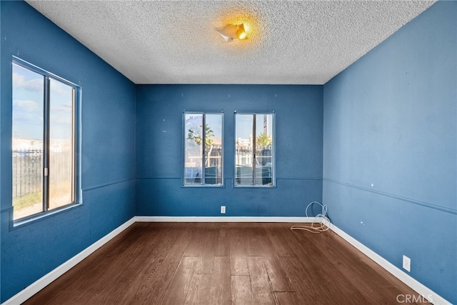15430 Parthenia St, North Hills, CA 91343 - unfurnished room featuring baseboards, a healthy amount of sunlight, wood finished floors, and a textured ceiling