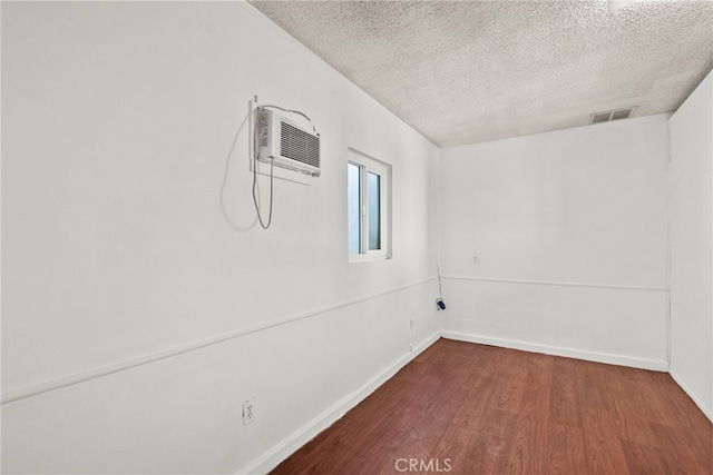 15430 Parthenia St, North Hills, CA 91343 - spare room with a wall mounted air conditioner, a textured ceiling, dark wood finished floors, baseboards, and visible vents