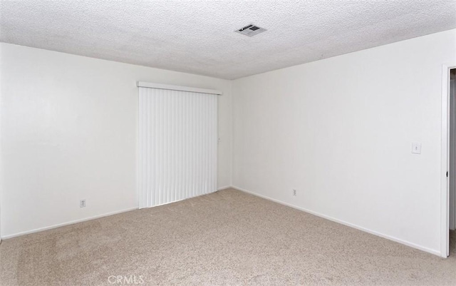 unfurnished room featuring light colored carpet, baseboards, and a textured ceiling