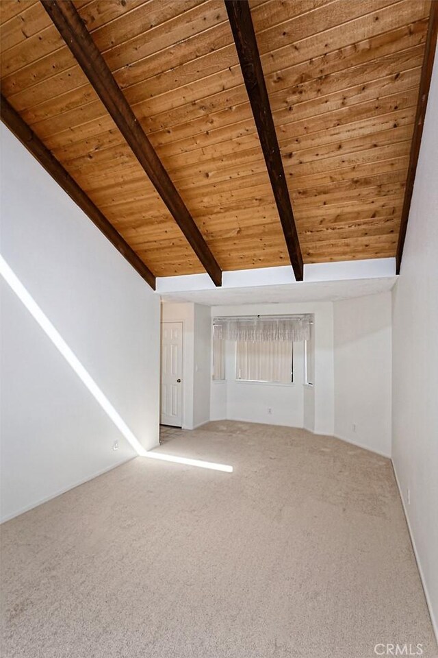 unfurnished living room featuring wood ceiling, lofted ceiling with beams, and carpet floors